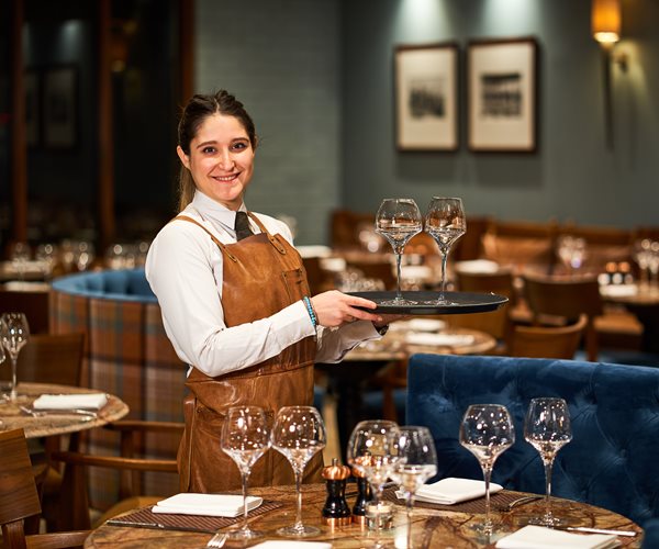 Waitress Setting Up Tables With Wine Glasses In The Oban Bay Grill Room Restaurant 