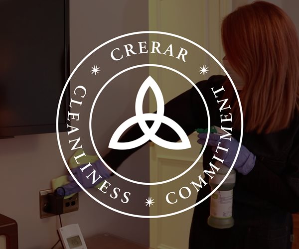 Female Cleaner Sanitising Hotel Room At Crerar Hotels 
