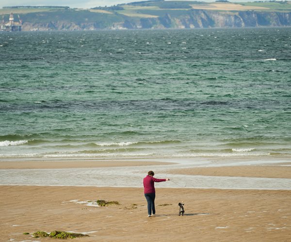 Lady Walking Dog on Beach at Golf View Nairn