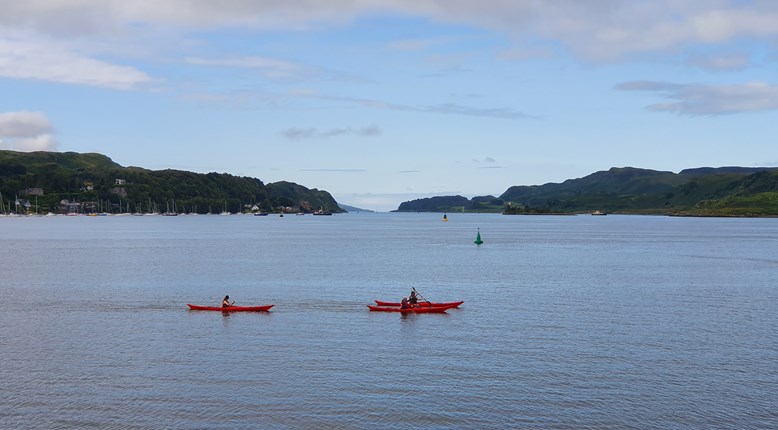 A family kayaking on the Oban Sea.