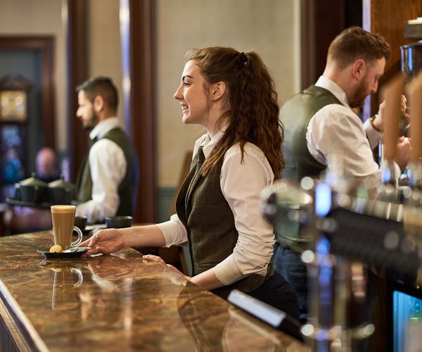 Barista Serving A Latte At Crerar Hotels Bar 