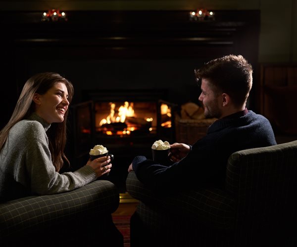 Couple Relaxing By Fire on Hotel Break in Scotland 